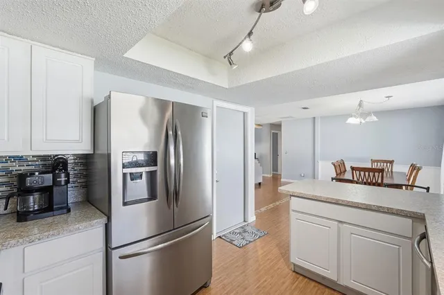 a kitchen with refrigerator a microwave and cabinets
