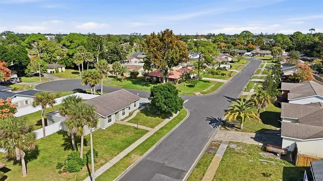 an aerial view of residential houses with outdoor space and trees all around