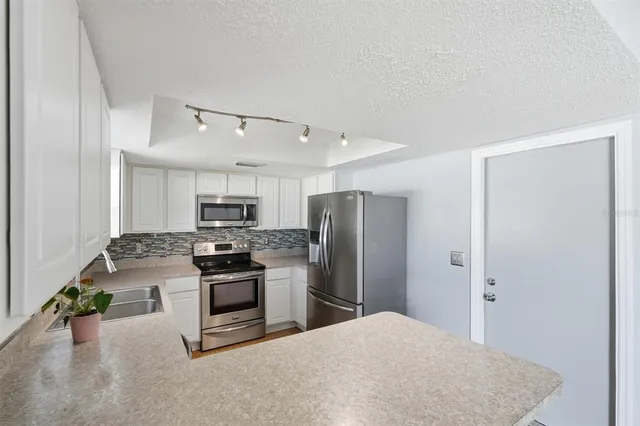 a kitchen with kitchen island a stove a table and chairs in it