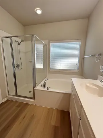 a bathroom with a tub a sink and a mirror