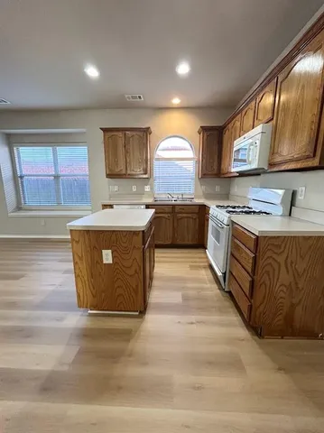a kitchen with stainless steel appliances granite countertop wooden cabinets and sink
