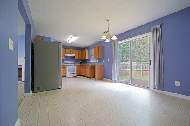 a open kitchen with stainless steel appliances granite countertop a refrigerator and a stove top oven