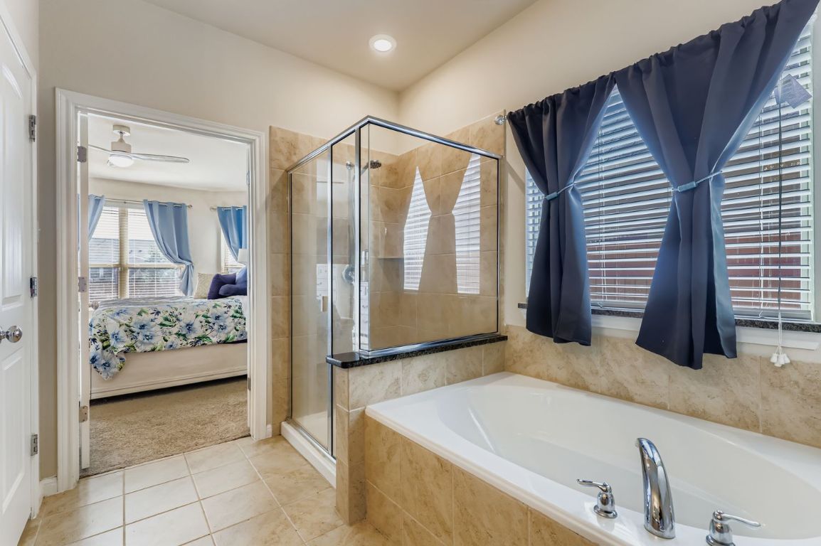 19433 Colgin Drive Pflugerville, TX 78660 - Photo 15 of 29 a bathroom with a tub sink and glass door