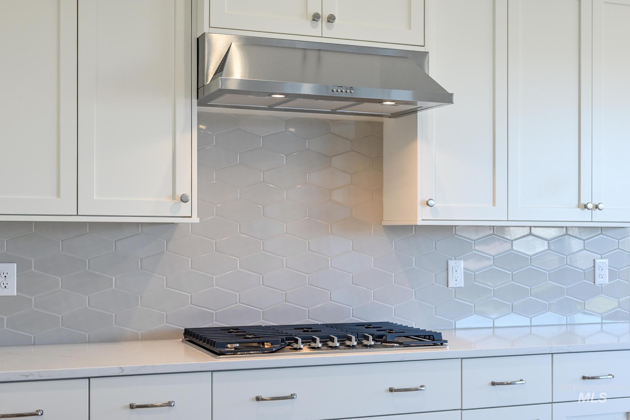 9800 West Novato Street Star, ID 83669 - Photo 12 of 40 Kitchen with backsplash, light stone countertops, and white cabinets