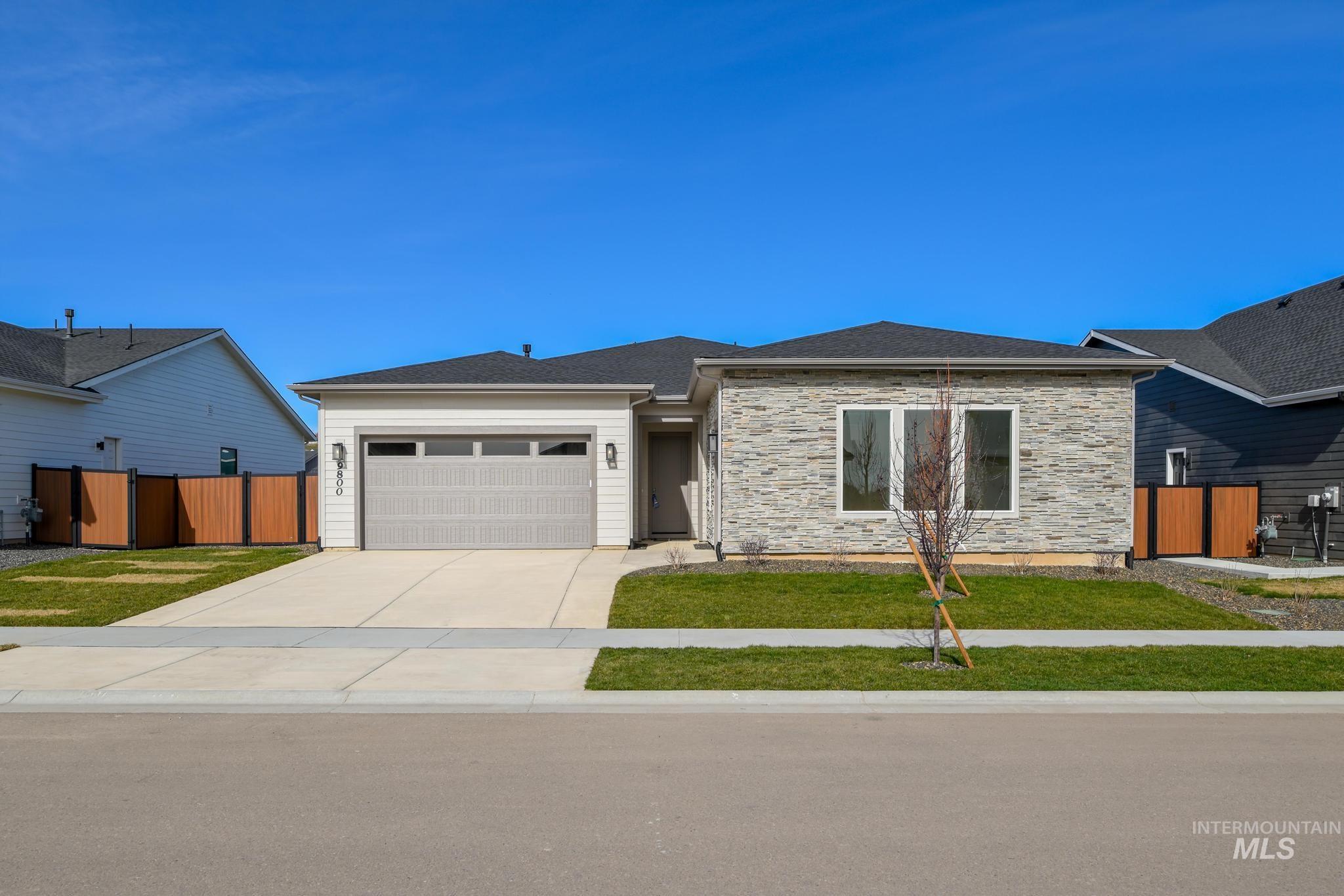 9800 West Novato Street Star, ID 83669 - Photo 2 of 40 View of front of home featuring driveway, an attached garage, and stone siding