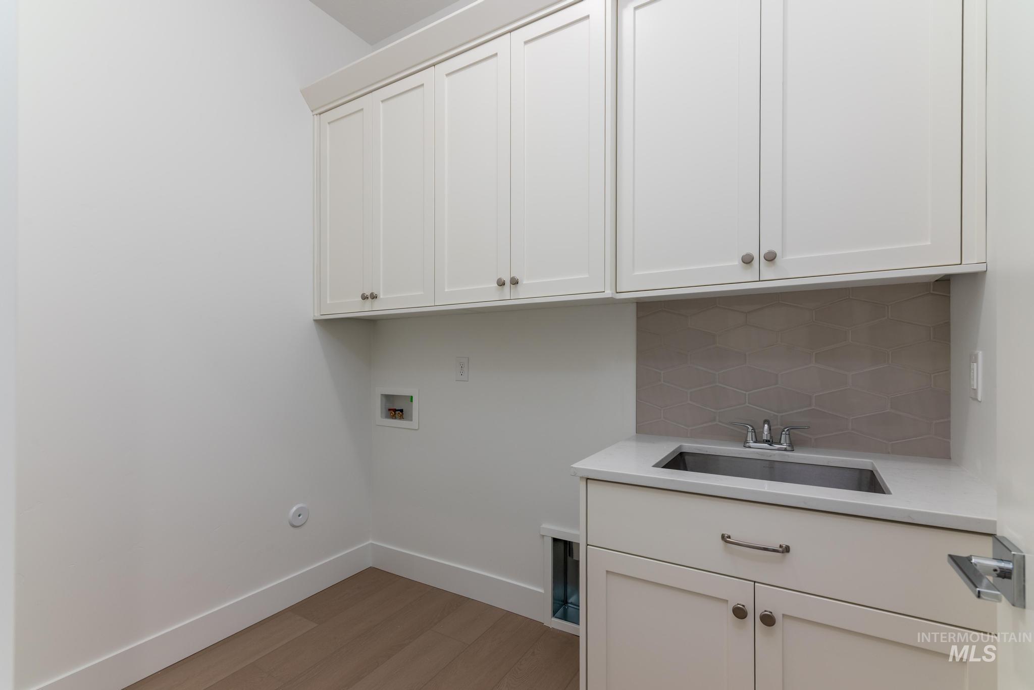 9800 West Novato Street Star, ID 83669 - Photo 26 of 40 Laundry area with light wood-style flooring, hookup for a washing machine, and cabinet space