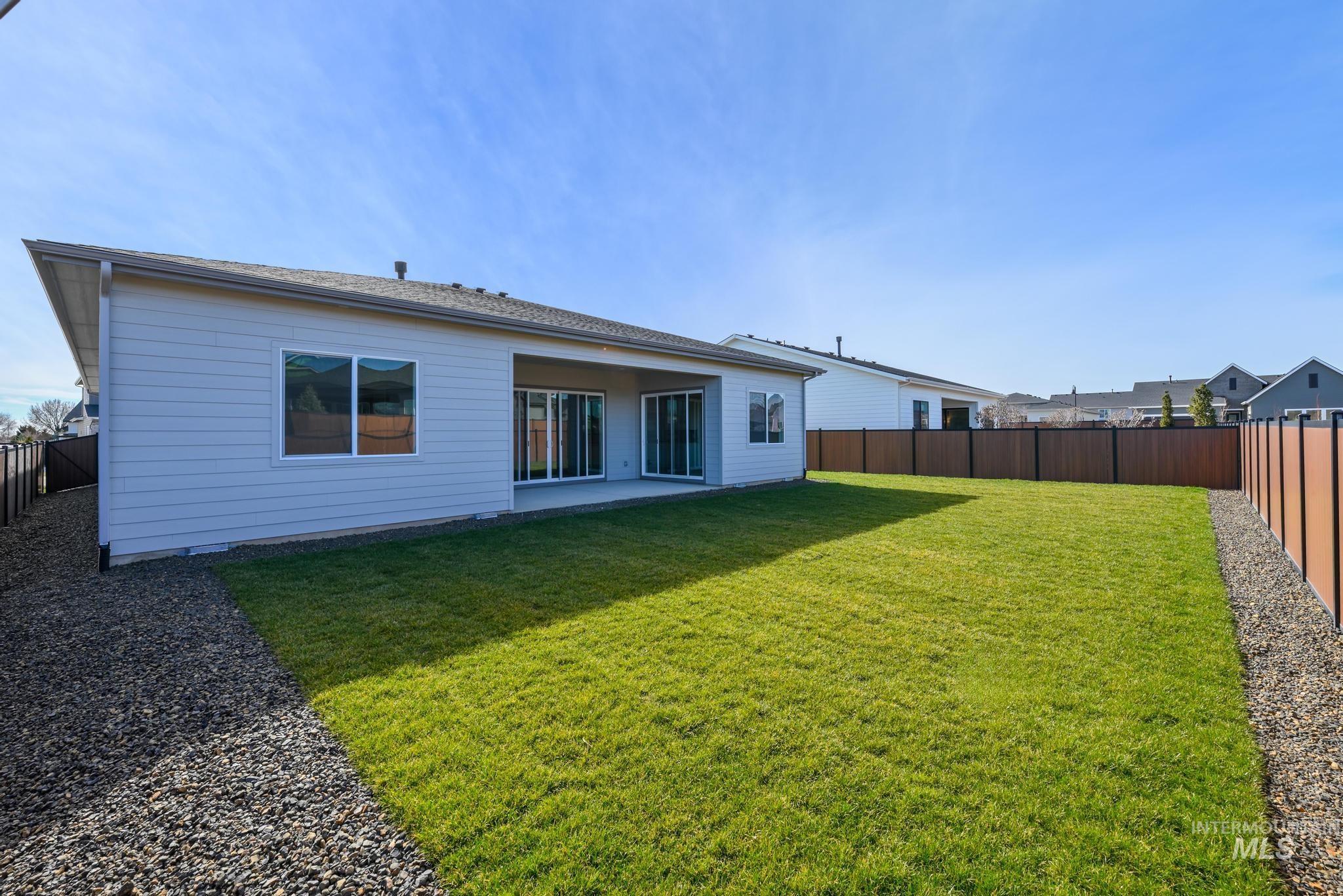 9800 West Novato Street Star, ID 83669 - Photo 28 of 40 Back of property with a fenced backyard and a patio area