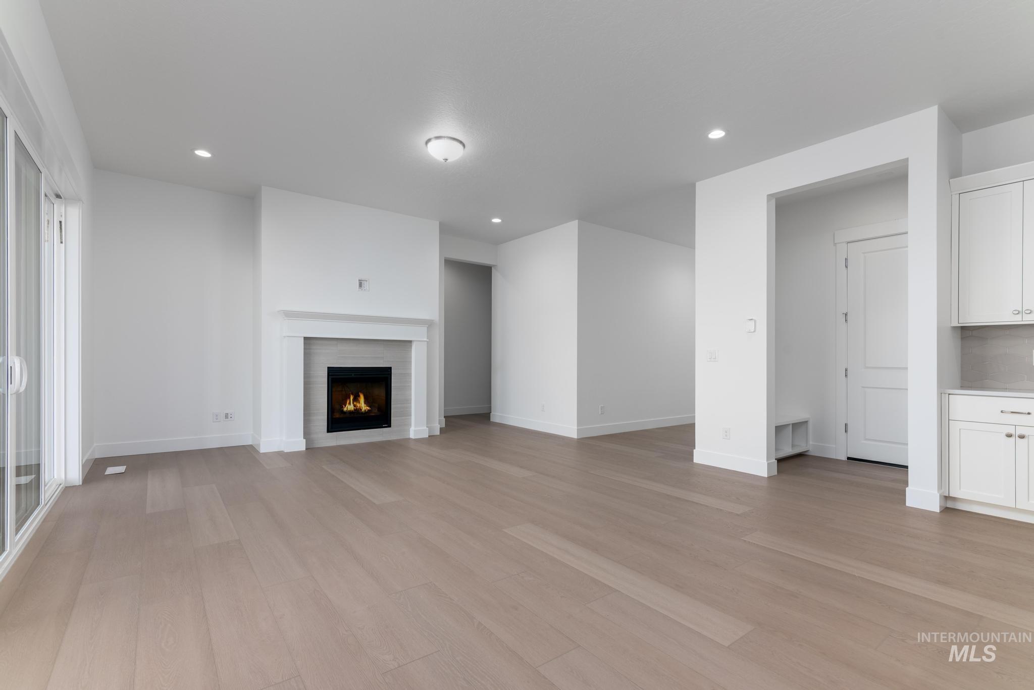 9800 West Novato Street Star, ID 83669 - Photo 4 of 40 Unfurnished living room with light wood-style floors, a lit fireplace, and recessed lighting