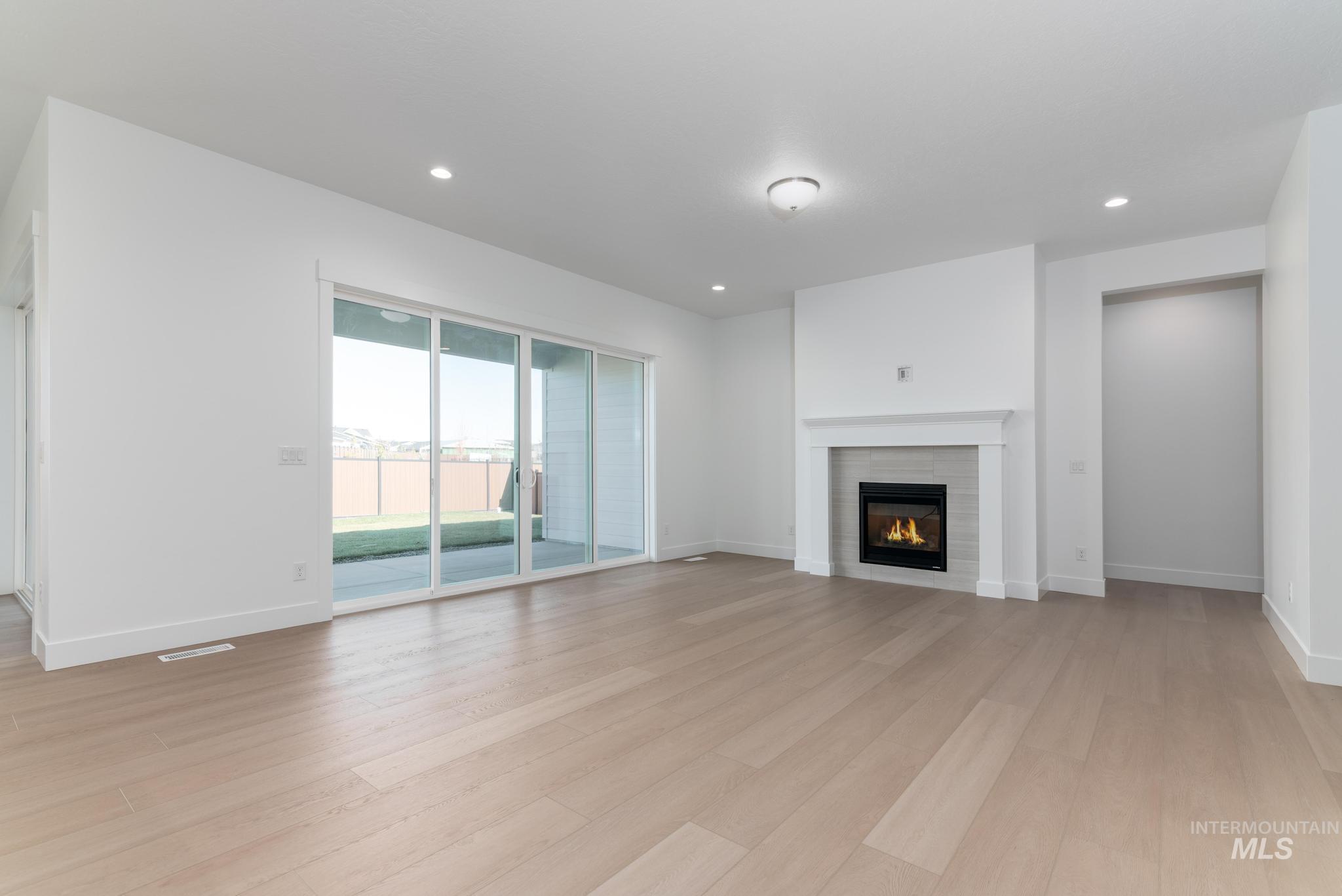 9800 West Novato Street Star, ID 83669 - Photo 5 of 40 Unfurnished living room featuring a fireplace, light wood-style flooring, and recessed lighting