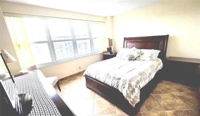 a bedroom with a bed and a mirror with a chair