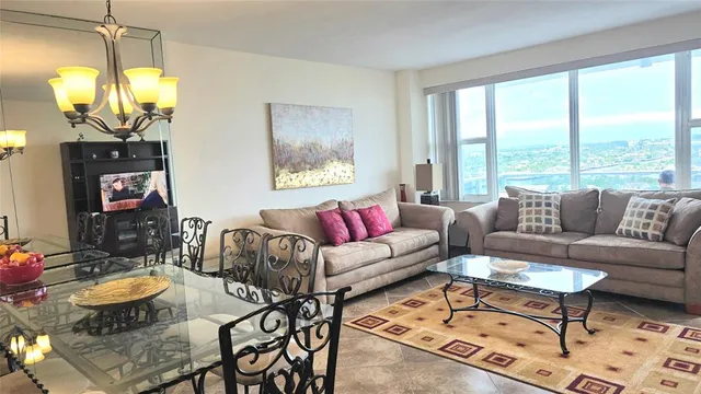 a living room with furniture a lamp a rug and a large window