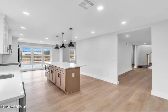 a large kitchen with stainless steel appliances granite countertop a large counter top and a wooden floors