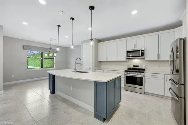 a kitchen with a sink stainless steel appliances and window