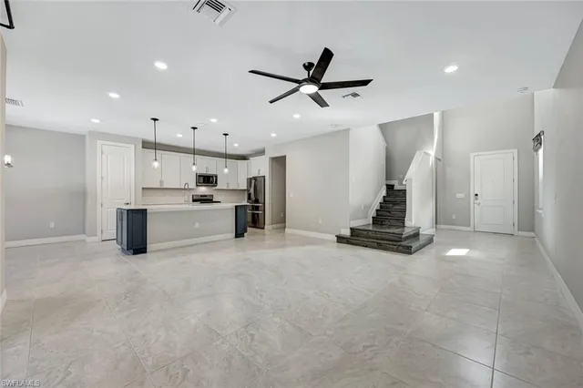 a view of a kitchen with refrigerator and white cabinets