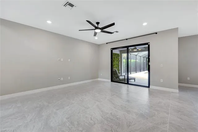 an empty room with fan and windows