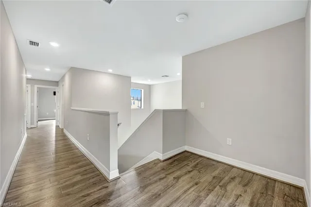 a view of a hallway with wooden floor