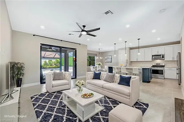 a living room with furniture ceiling fan and a rug