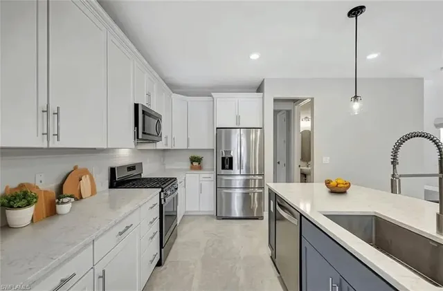 a kitchen with a sink dishwasher a refrigerator and cabinets
