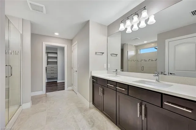 a spacious bathroom with a granite countertop sink a toilet a mirror and shower