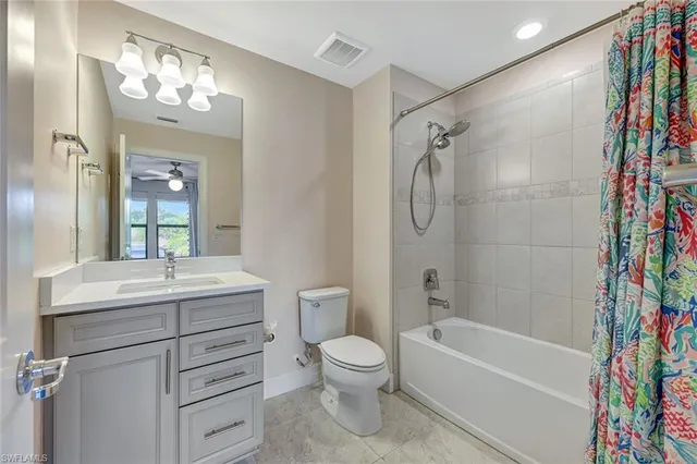 a bathroom with a sink a toilet a mirror a vanity a bathtub and shower