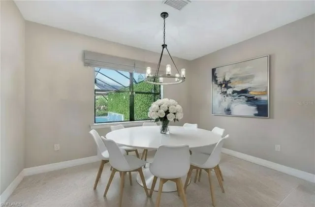 a dining room with furniture a large window and a chandelier