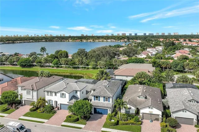 an aerial view of residential houses with outdoor space and lake view