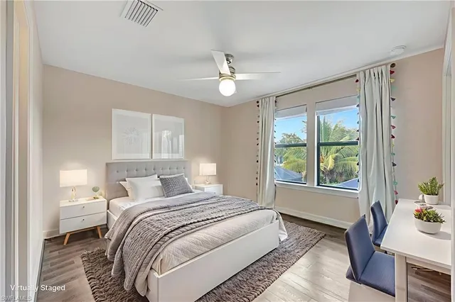 a bedroom with a bed chandelier and a window