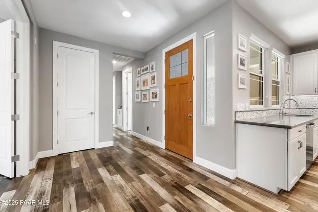 a view of a hallway with wooden floor and cabinet