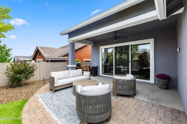 a view of a patio with table and chairs potted plants and a large tree