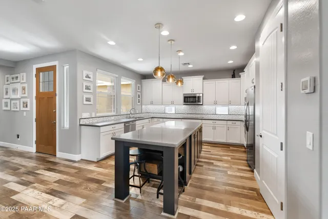 a kitchen with kitchen island a sink stainless steel appliances and cabinets