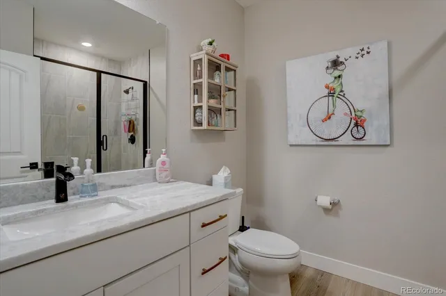 a bathroom with a granite countertop sink a toilet and mirror