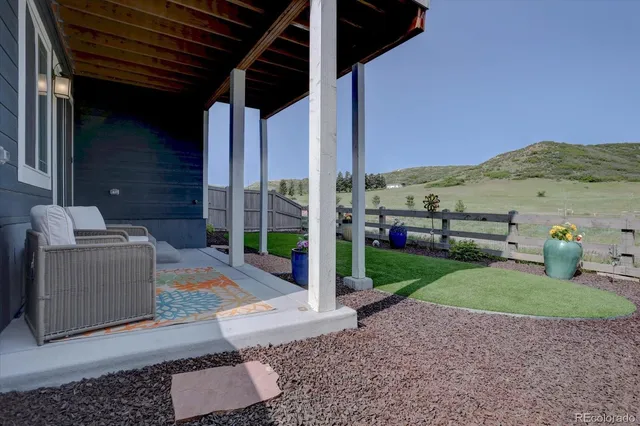 a view of a patio with chairs and a garden