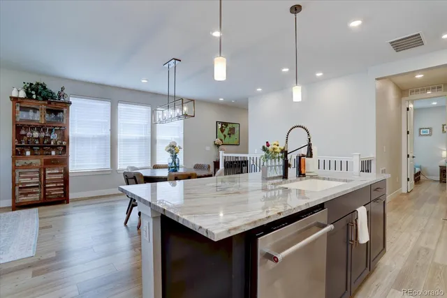 a kitchen with stainless steel appliances granite countertop a stove and kitchen island with wooden floor