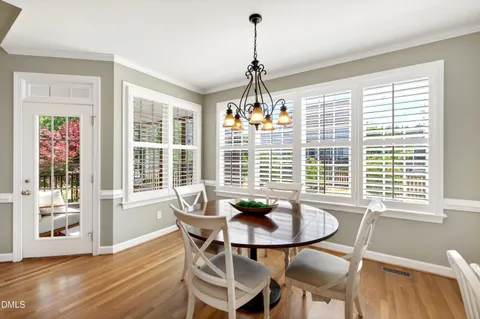 a dining room with furniture a chandelier and wooden floor