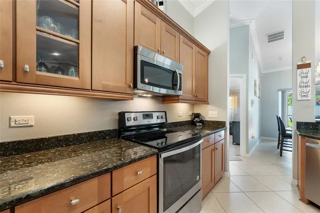 a kitchen with granite countertop a sink stove and cabinets