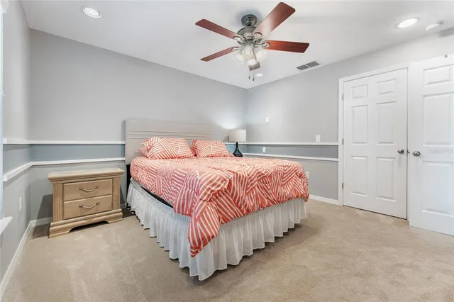 a spacious bedroom with a bed and a chandelier