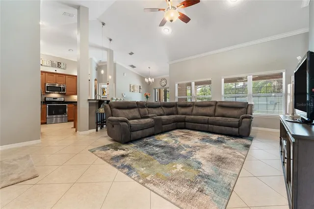a living room with furniture kitchen view and a large window