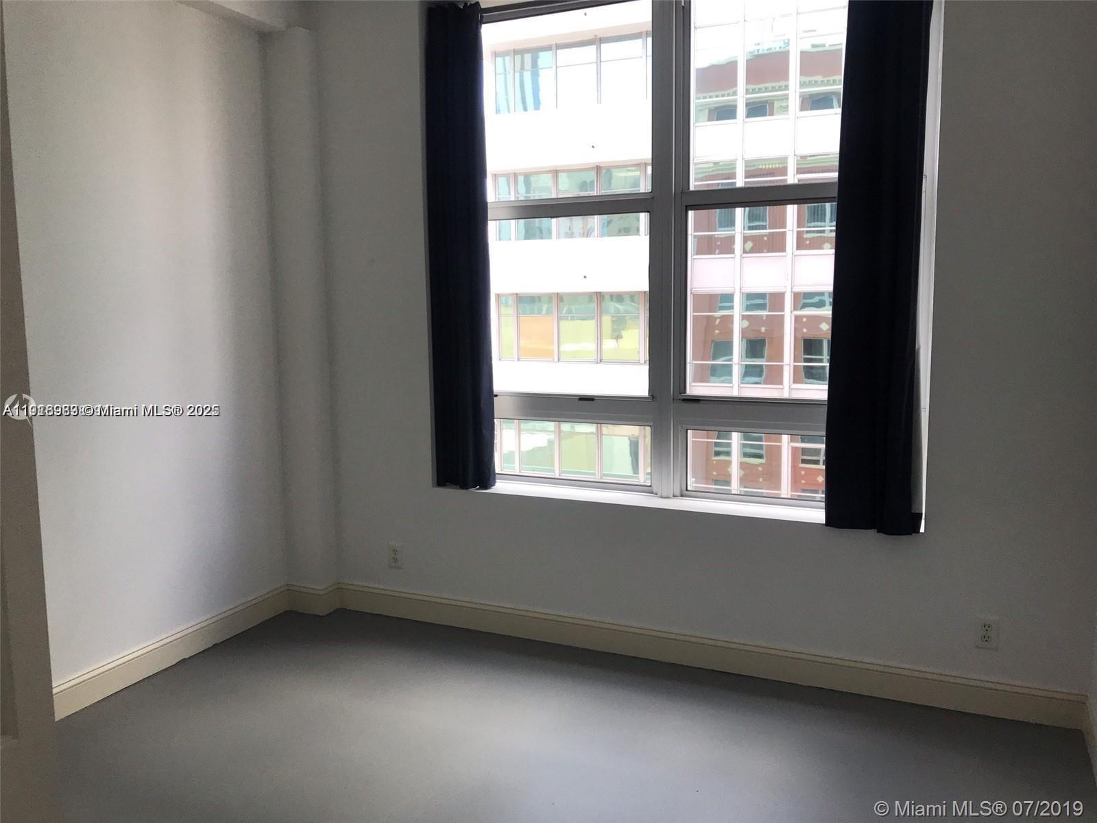 111 East Flagler Street, Unit 803 Miami, FL 33131 - Photo 5 of 16 an empty room with a window