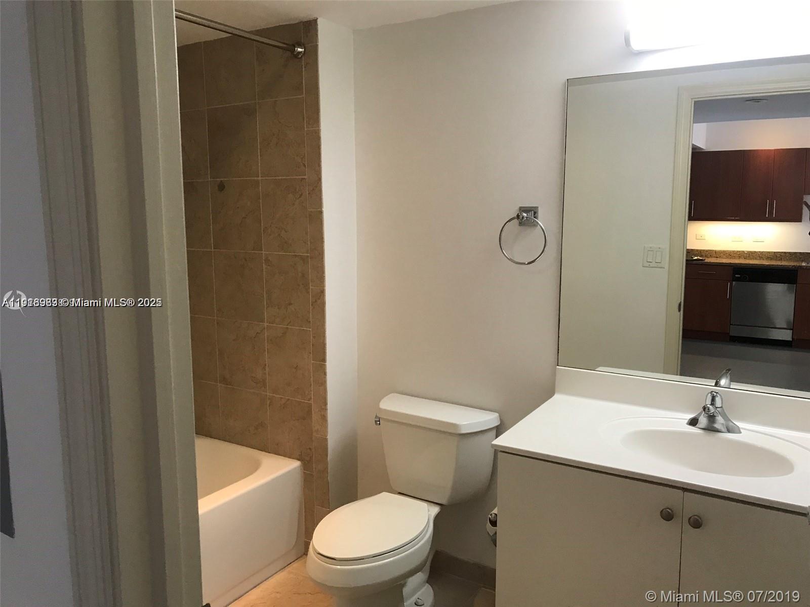 111 East Flagler Street, Unit 803 Miami, FL 33131 - Photo 9 of 16 a bathroom with a sink a toilet and shower