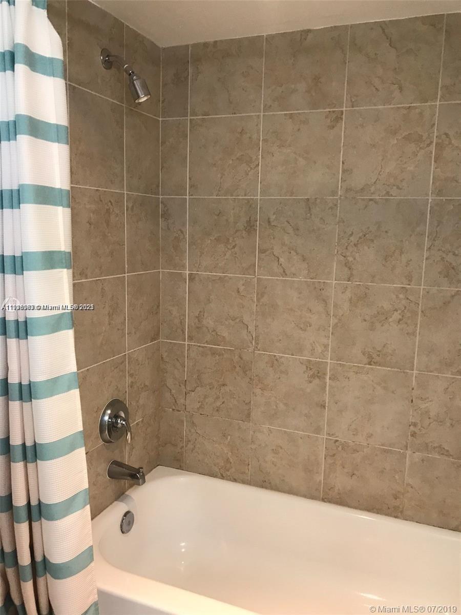 111 East Flagler Street, Unit 803 Miami, FL 33131 - Photo 10 of 16 a bathroom with a bathtub and a shower