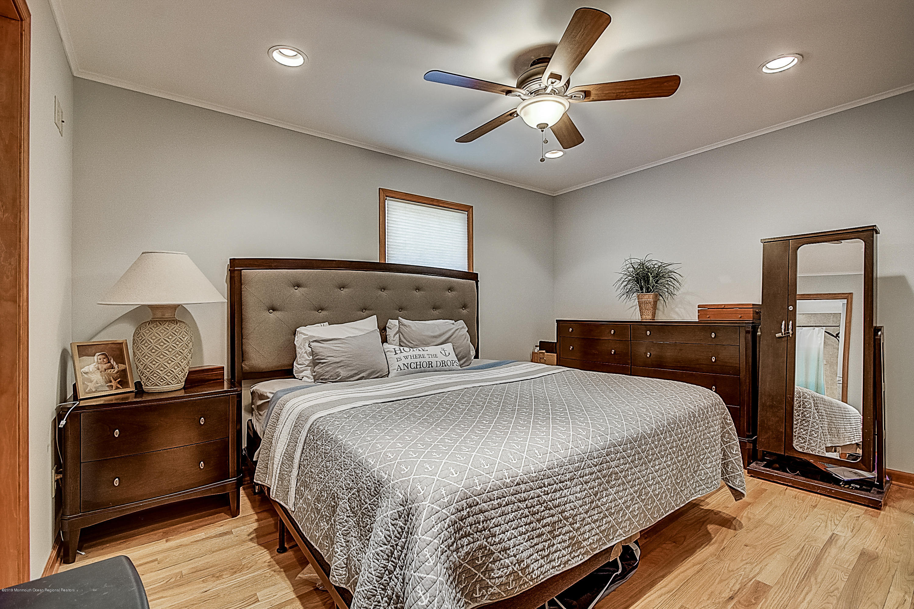 2302 Oak Tree Road Point Pleasant, NJ 08742 - Photo 19 of 48 a bedroom with a large bed and a chandelier
