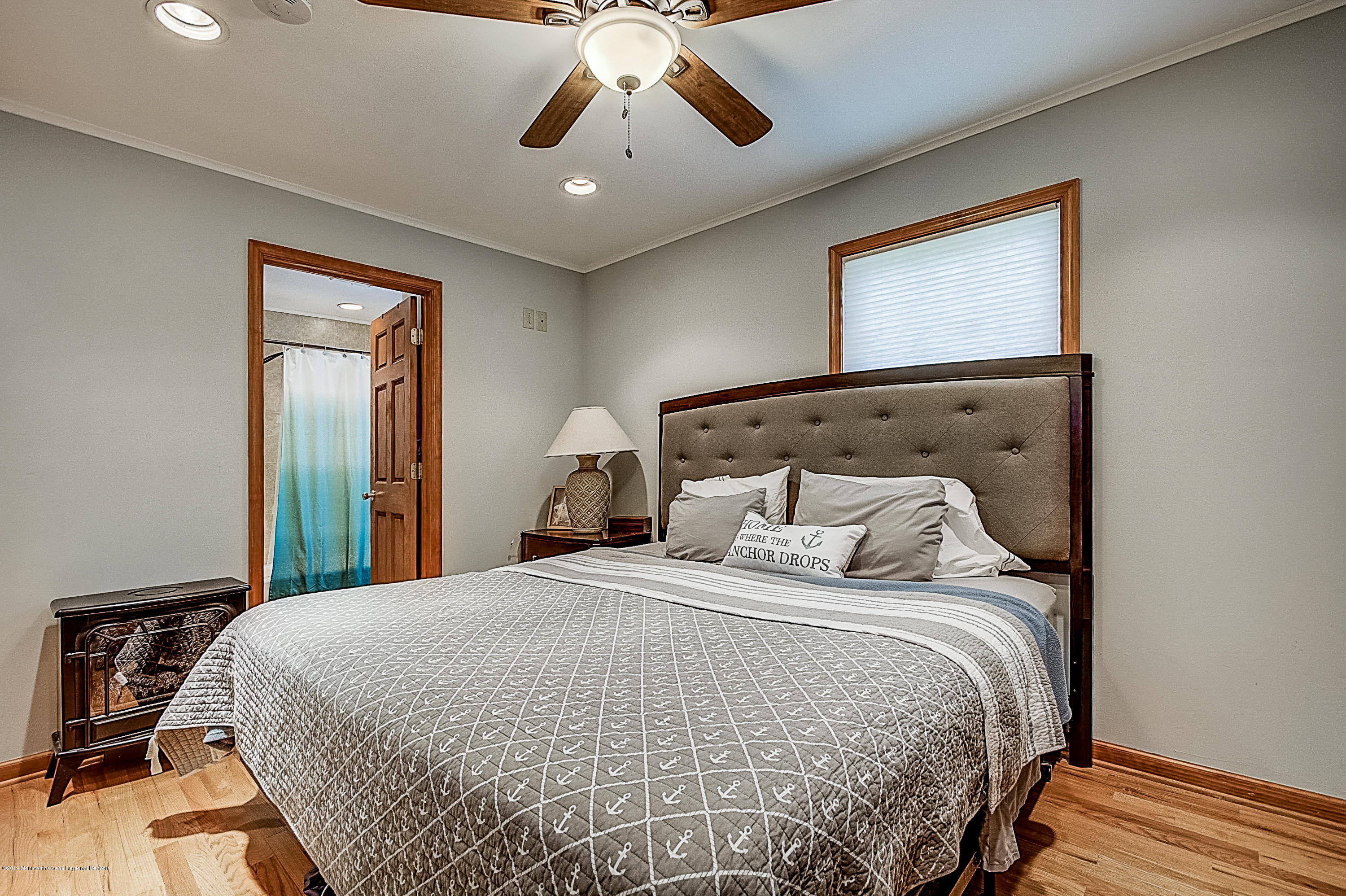 2302 Oak Tree Road Point Pleasant, NJ 08742 - Photo 20 of 48 a bedroom with a large bed and a chandelier