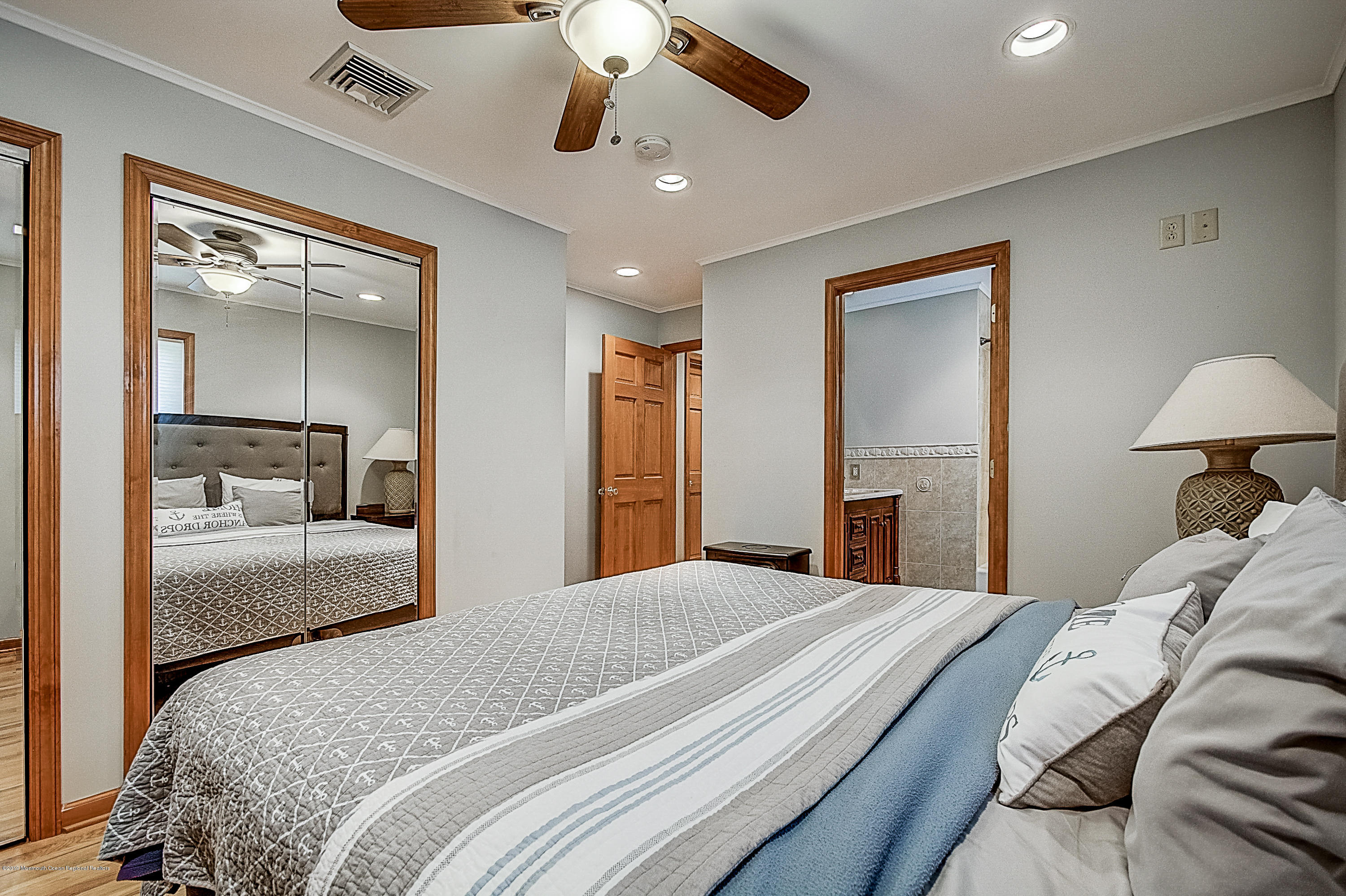 2302 Oak Tree Road Point Pleasant, NJ 08742 - Photo 21 of 48 a bedroom with a large bed and a chandelier