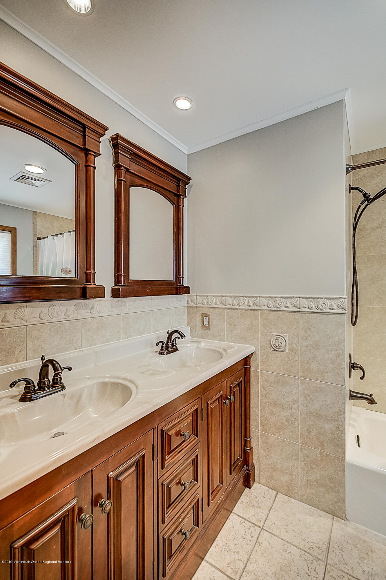 2302 Oak Tree Road Point Pleasant, NJ 08742 - Photo 24 of 48 a bathroom with a double vanity sink a mirror and a bathtub