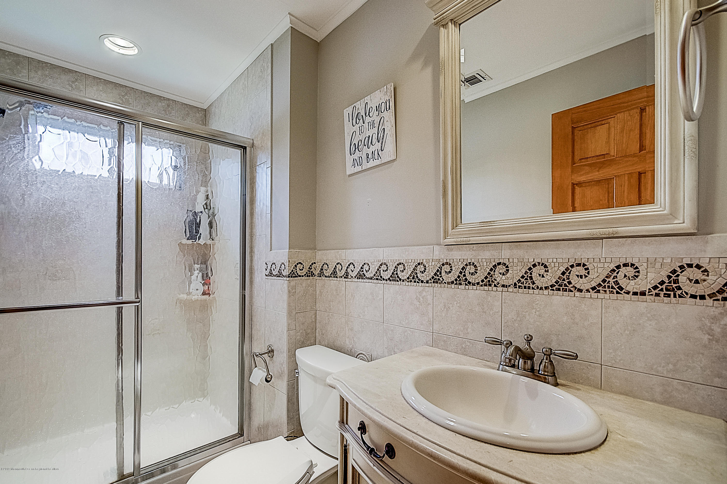 2302 Oak Tree Road Point Pleasant, NJ 08742 - Photo 29 of 48 a bathroom with a sink a mirror and a shower