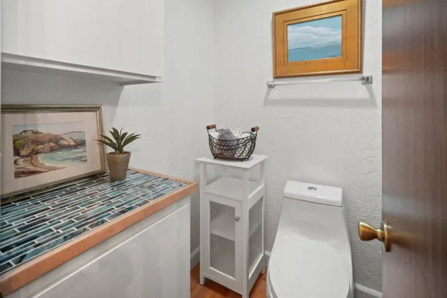 a bathroom with a granite countertop toilet and a sink