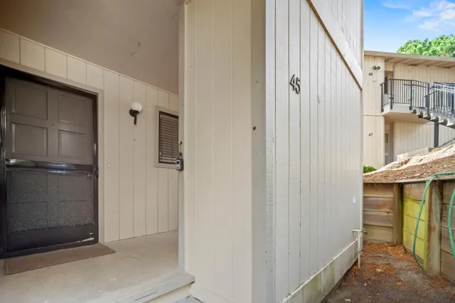 a view of a hallway with a door and stairs