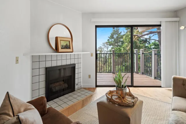 a living room with furniture a large window and a fireplace