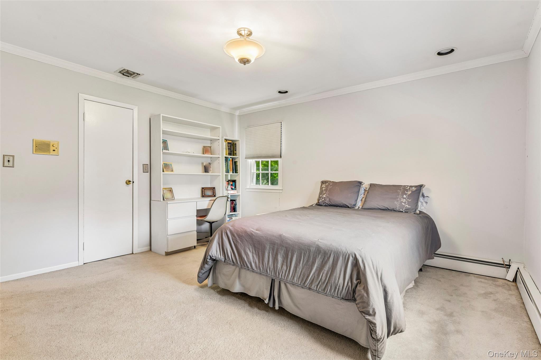 100 Hewlett Neck Road Woodmere, NY 11598 - Photo 26 of 45 a bedroom with a bed and a lamp on the dresser