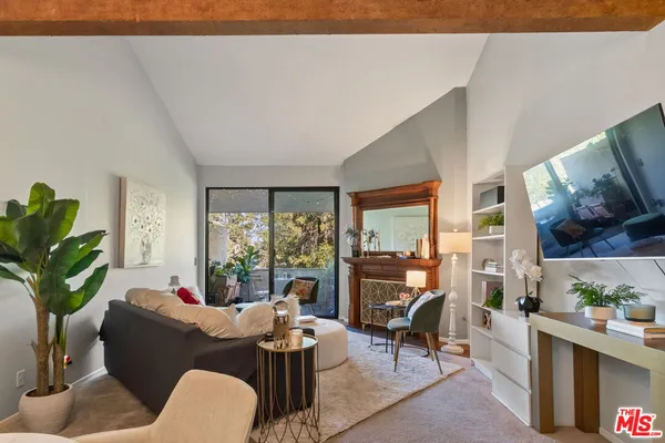 a living room with furniture a large window and a dining table